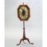 A Victorian pole screen with octagonal wool work banner raised on turned column and tripod base