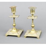 A pair of Victorian brass candlesticks raised on square bases 16cm h x 8cm w x 8cm dOne sconce is