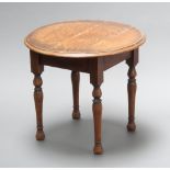 A 1930's circular oak occasional table raised on turned supports 51cm x 60cm Ring and water marks,