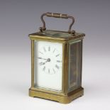 A 19th Century carriage timepiece with enamelled dial and Roman numerals, contained in a gilt