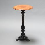 A Victorian circular walnut wine table raised on an ebonised baluster turned column with paw feet