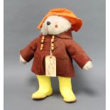 A Gabrielle Designs Paddington bear with duffle coat, label and yellow Dunlop wellingtonsThere is