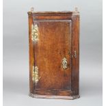 A 17th/18th Century oak hanging corner cabinet fitted shelves enclosed by a panelled door 46cm h x