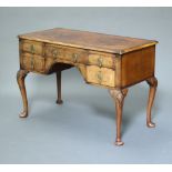 A Queen Anne style crossbanded walnut writing table fitted a drawer flanked by 4 short drawers,