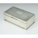 An Art Deco rectangular silver engine turned cigarette box on ogee bracket feet Birmingham 1937,