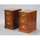 A pair of oak bedside chests of 3 drawers, raised on platform base with brass swan neck drop handles