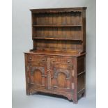 A 17th Century Ipswich style oak dresser the raised back with shaped cornice fitted 2 shelves, the