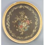 A Victorian oval woolwork picture, floral study within laurel leaves, contained in a decorative gilt