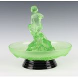 An Art Deco moulded green glass floral centrepiece with figures of children (chipped) the bowl
