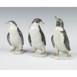 Three Lladro figures of standing penguins 16cm, 15cm and 14cm The last penguin has a stuck beak