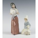 A Lladro figure of a girl holding a hat before her 5007 25cm, a ditto of a boy Shepherd 14cm (f)