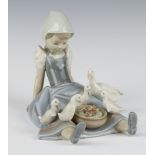 A Lladro figure of a seated goose girl 18cm