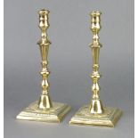 A pair of Georgian polished brass candlesticks raised on square bases 28cm h x 11cm x 11cm One has