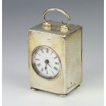 An Edwardian silver hammered pattern table timepiece on bun feet Birmingham 1907, 11cm In working
