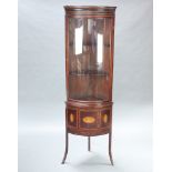 A 19th Century inlaid mahogany bow front corner cabinet, the upper section fitted a shelf with