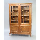 A French oak display cabinet fitted adjustable shelves enclosed by astragal glazed panelled doors,