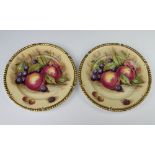 Aynsley, a pair of plates decorated peaches and grapes with gilt borders 26cm, signed D James
