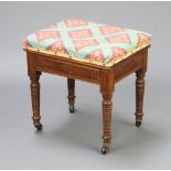 An Edwardian walnut box seat piano stool with upholstered seat raised on turned and fluted