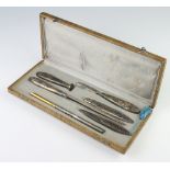 A Continental white metal repousse desk set (6), cased with floral decoration