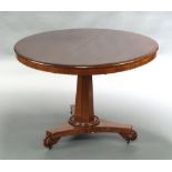 A Victorian circular mahogany snap top breakfast table raised on a chamfered column and tripod
