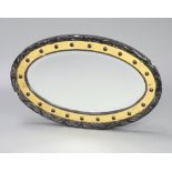 A Victorian oval bevelled plate wall mirror contained in an ebonised and gilt ball studded frame