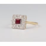 A yellow metal stamped 18ct Art Deco style ruby and diamond ring, the centre stone 0.4ct