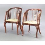 A pair of Edwardian stick and tub back armchairs with Berlin woolwork seats, raised on cabriole