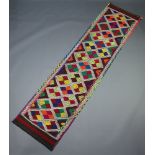 A blue, orange, white and red ground Suzni kilim runner with all over geometric design, 270cm x 67cm