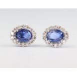 A pair of white metal stamped 18ct oval sapphire and diamond ear studs, the sapphires 1.61ct, the