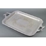 A silver plated two handled tray with floral and scroll rim and pierced decoration 66cm
