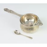 An Art Deco silver tea strainer, Birmingham 1938, together with a silver holder and spoon, 80gms