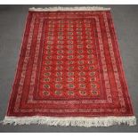 A red and white ground Afghan carpet with multi row border and 75 octagons to the centre 278cm x