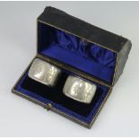 A pair of Edwardian silver napkin rings with floral decoration, cased, Sheffield 1901, 60gms