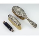 A white metal mounted double ended blue glass scent together with repousse hair brush and clothes
