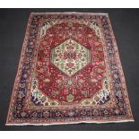 A red and blue ground Persian carpet with central medallion within a multi row border 297cm x