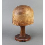 A turned wooden hat block on a associated stand, the base marked 201 22, 28cm x 18cm x 14cm