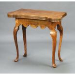 A French Georgian style oak card table with shaped outline, candle and money wells, raised on