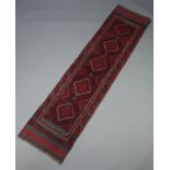 A blue and red ground Meshwani runner with 5 diamonds to the centre 250cm x 60cm