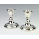 A pair of silver dwarf candlesticks with reeded decoration Birmingham 1916, 10cm