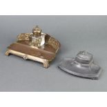 An Art Nouveau embossed gilt metal and glass standish, fitted an inkwell, raised on panelled