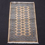 A gold and black ground Bokhara rug with 24 octagons to the centre 163cm x 93cm