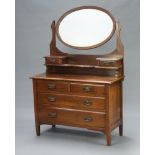 An Edwardian Art Nouveau mahogany dressing chest with oval bevelled plate wall mirror, the base