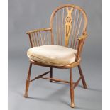 A beech framed Windsor stick and wheel back armchair with woven cane seat raised on turned