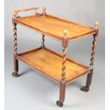 A 1930's rectangular oak 2 tier tea trolley raised on spiral turned supports 76cm h x 81cm w x
