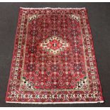 A red, blue and white ground Persian rug with central medallion 203cm x 149cm