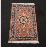 A machine made pink and blue ground Persian style rug 146cm x 91cm
