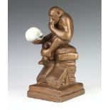 After Hugo Rheinhold, a mid-Century plaster figure of a chimpanzee holding a skull, sitting on a
