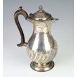 A Victorian silver baluster hot water jug with spiral decoration and engraved inscription and