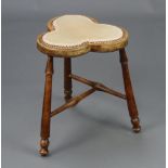 An Edwardian beech framed clover shaped stool with upholstered seat, on turned supports with T