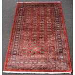 A burnt orange ground Bokhara with 72 octagons to the centre 248cm x 158cm